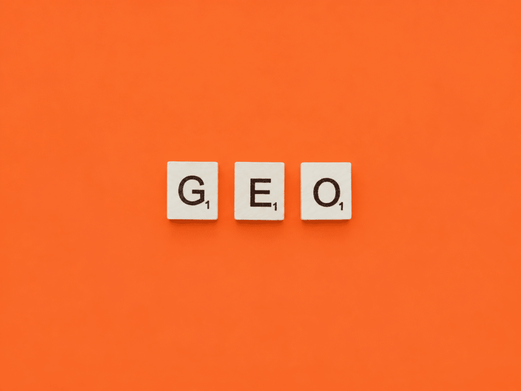 Fichas Scrabble formando GEO sobre fondo naranja